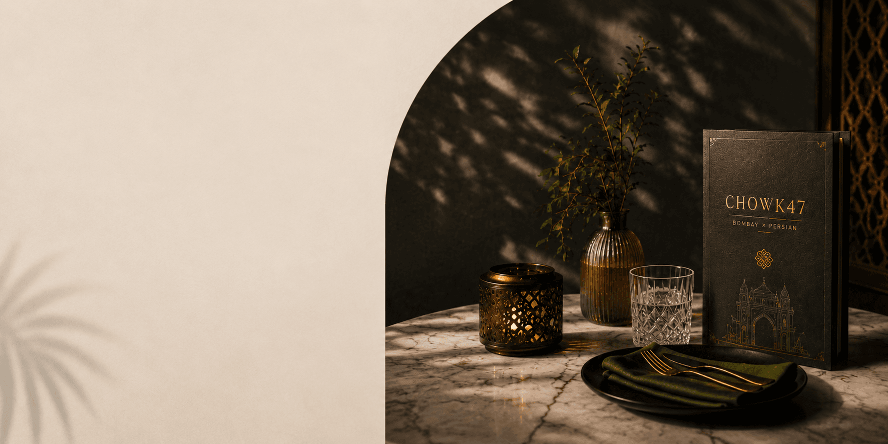 A warm Chowk47 table setting with candlelight, glassware and a menu